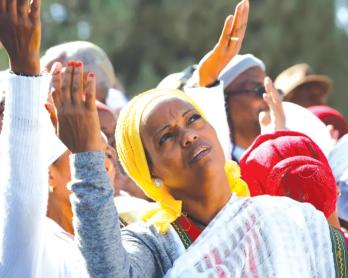 AN ISRAELI ETHIOPIAN woman prays during a ceremony